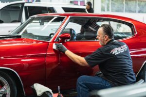 This photo is of a red Chevelle, an Auto Sport Detailing employee applying ceramic coating Santa Rosa services